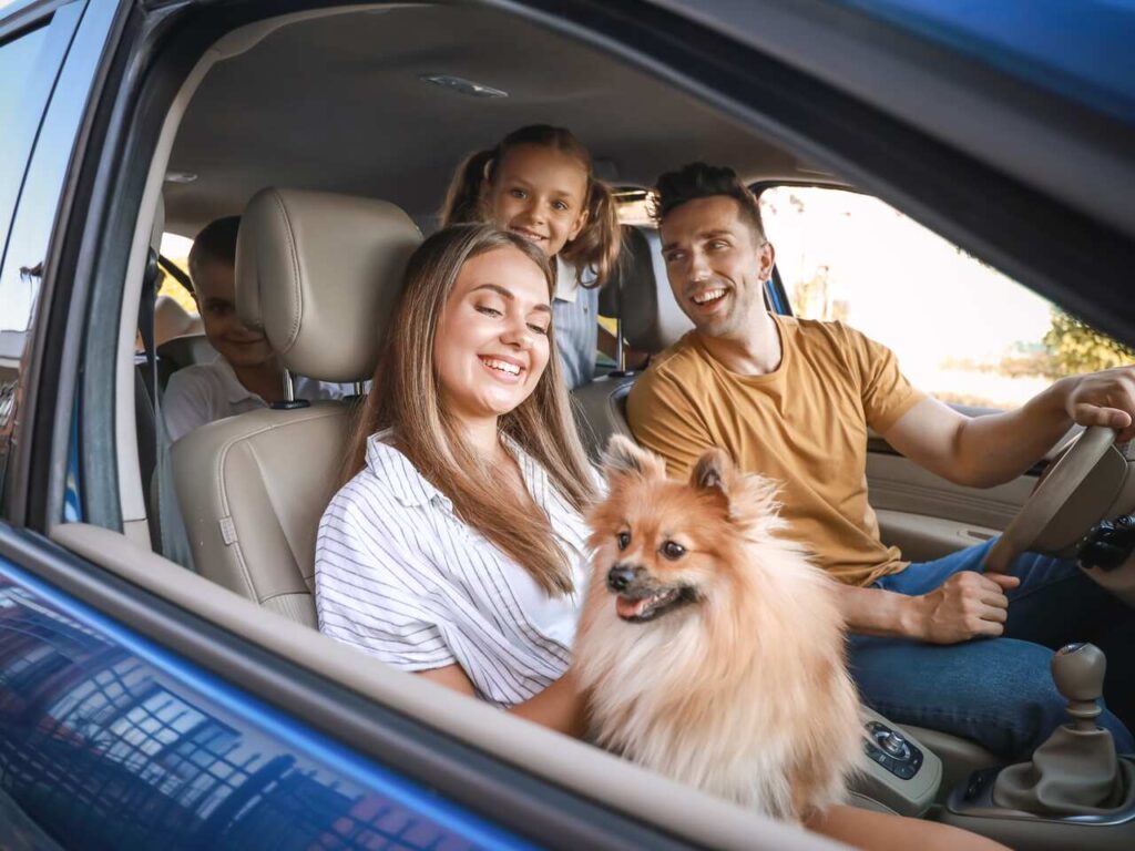 Szczęśliwa rodzina jadąca sprawdzonym samochodem w długą podróż.